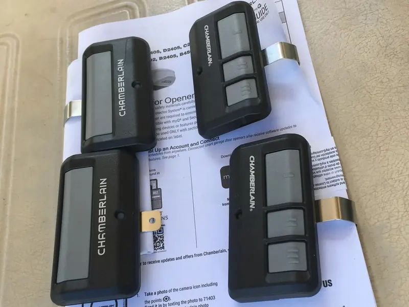 Four Chamberlain garage door remotes laid out on paper