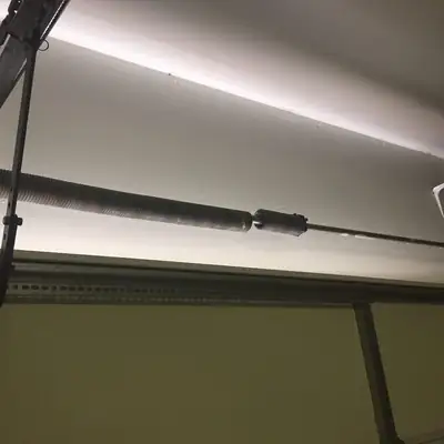 Torsion spring and cable on a door header